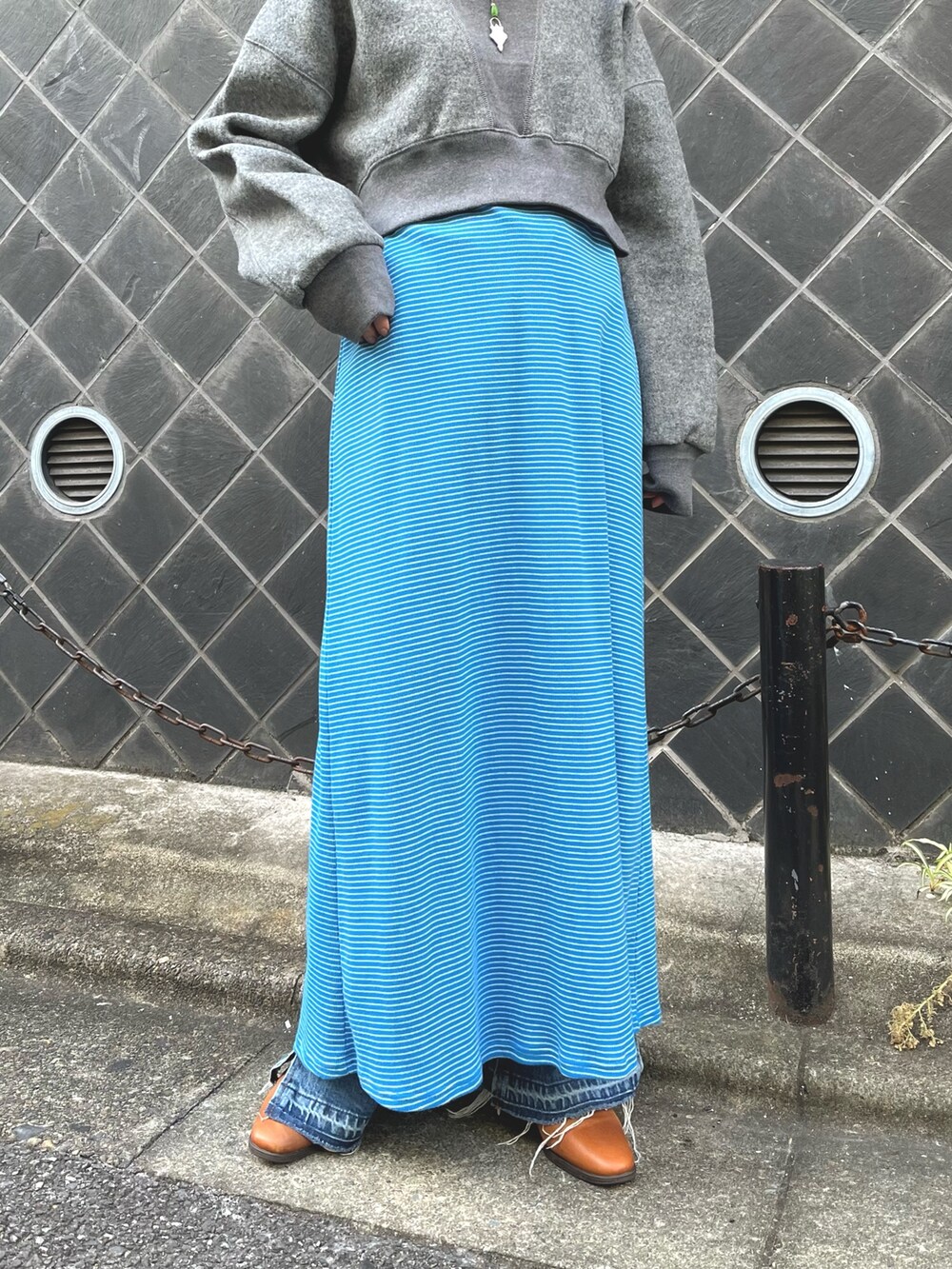 ブルー系のワンピース、ブルー系のデニムパンツ、グレー系のスウェットを着用したレディースの秋コーディネートの4枚目の写真
