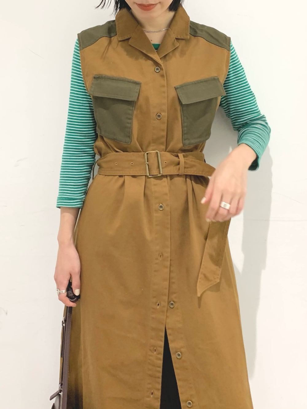 ブラウン系のベスト、ブラック系のパンツ、パープル系のショルダーバッグを着用したレディースの秋コーディネートの3枚目の写真