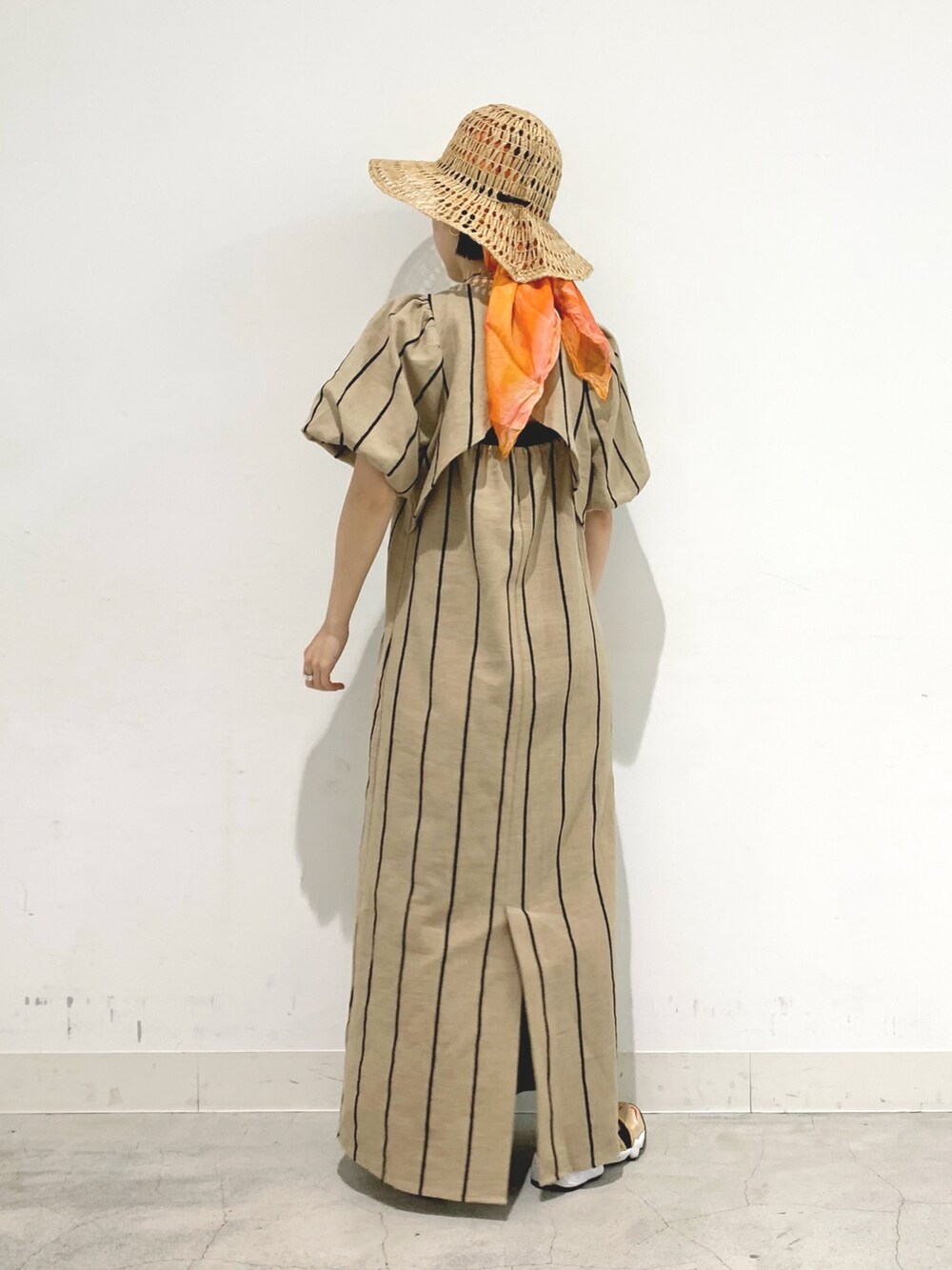 ベージュ系のワンピースを着用したレディースの春コーディネートの2枚目の写真