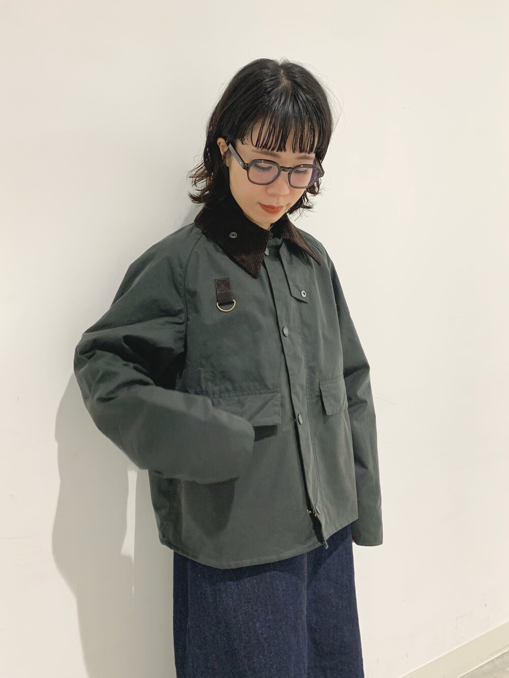 ブルー系のワンピース、ブラック系のポロシャツを着用したレディースの秋コーディネートの2枚目の写真