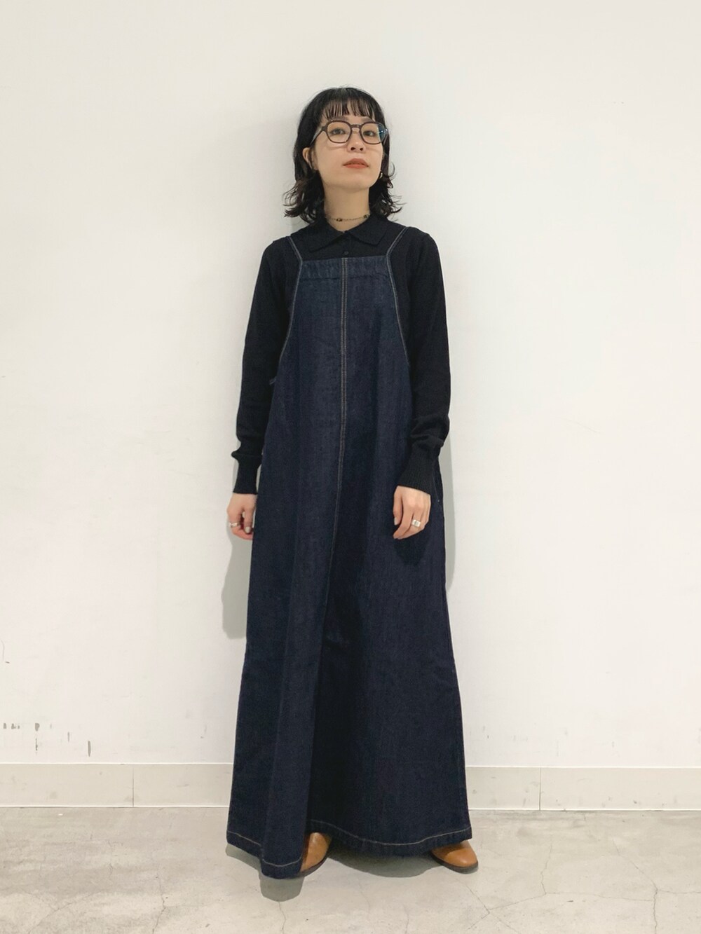 ブルー系のワンピース、ブラック系のポロシャツを着用したレディースの秋コーディネートの3枚目の写真