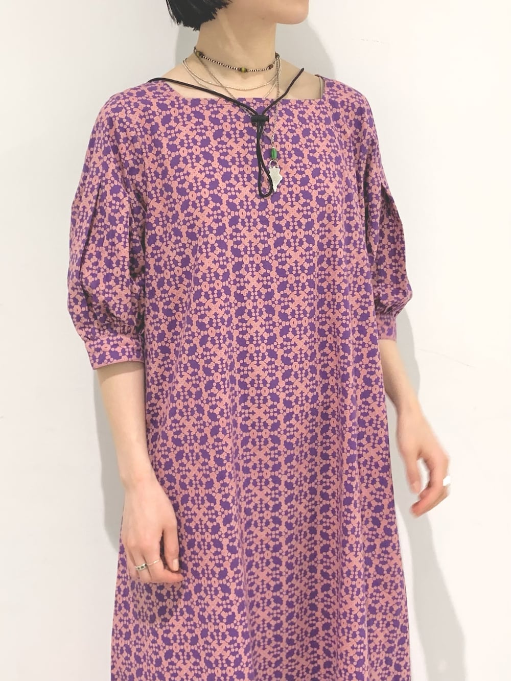 パープル系のワンピース、ブラック系のサンダル、ブラック系のハットを着用したレディースの夏コーディネートの3枚目の写真