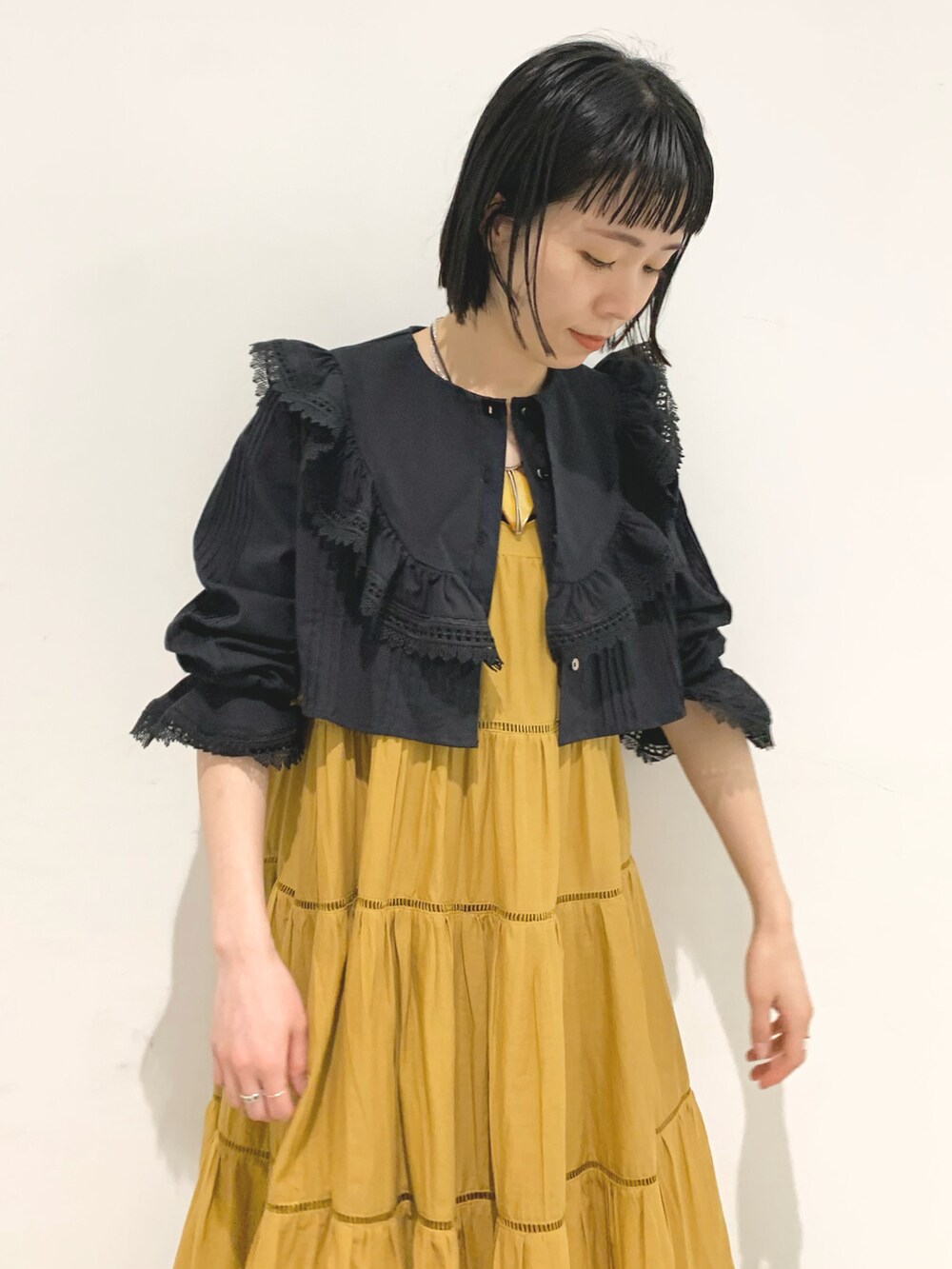 ベージュ系のワンピース、ブラック系のシャツ/ブラウスを着用したレディースの春コーディネートの4枚目の写真