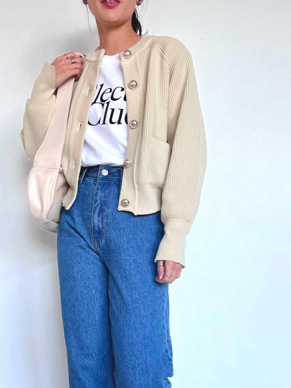 ホワイト系のカーディガン/ボレロ、ブルー系のデニムパンツ、ホワイト系のローファーを着用したレディースの冬コーディネートの3枚目の写真