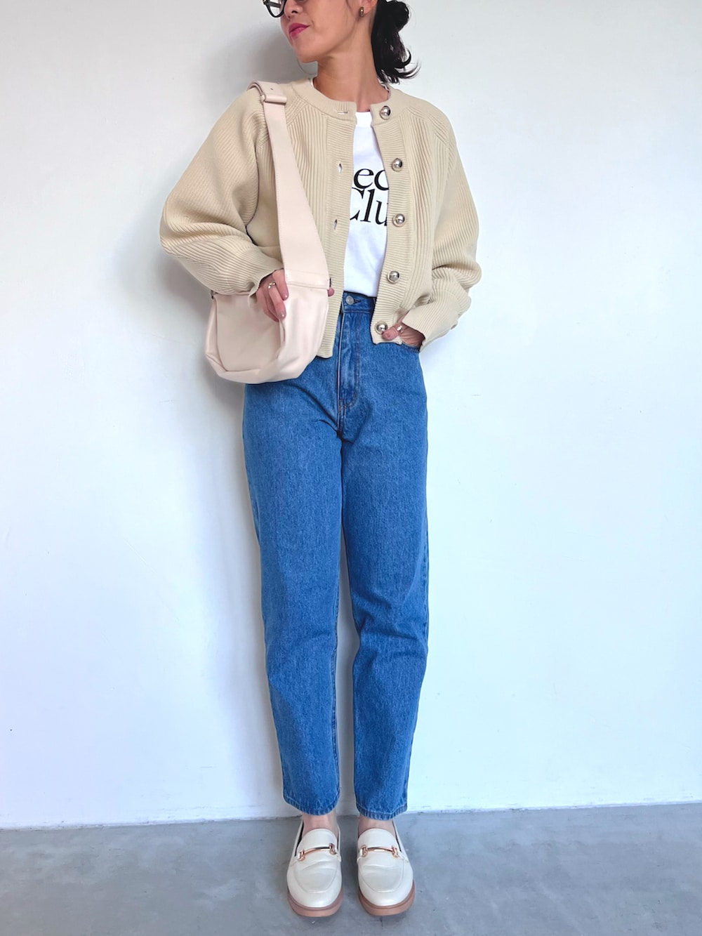 ホワイト系のカーディガン/ボレロ、ブルー系のデニムパンツ、ホワイト系のローファーを着用したレディースの冬コーディネートの2枚目の写真