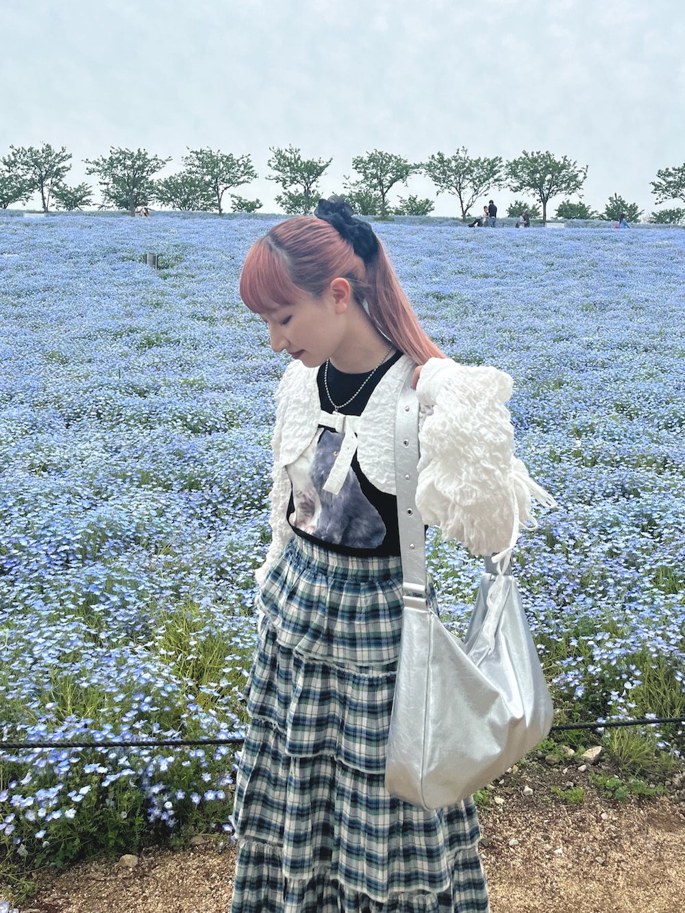 ホワイト系のカーディガン/ボレロ、ブラック系のTシャツ/カットソー、グリーン系のスカートを着用したレディースの春コーディネートの2枚目の写真