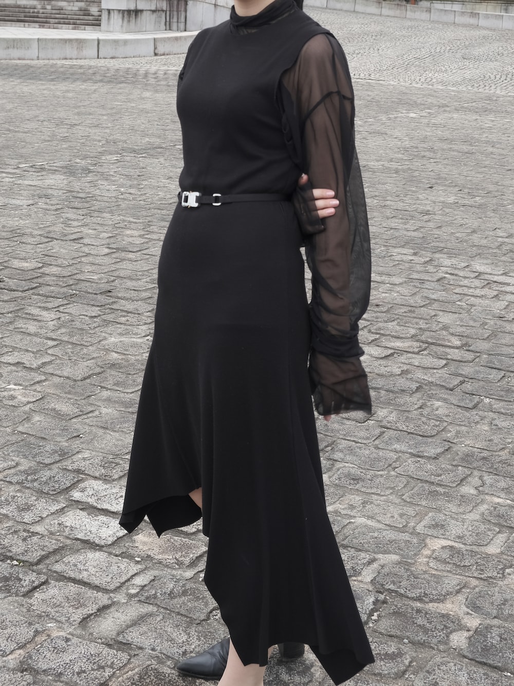 ブラック系のワンピース、ブラック系のサンダル、ブラック系のピアス（両耳用）を着用したレディースの夏コーディネートの2枚目の写真