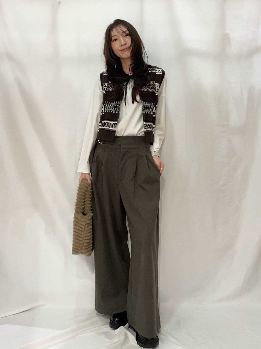 ブラウン系のその他パンツ、ブラウン系のベストを着用したレディースの冬コーディネートの2枚目の写真