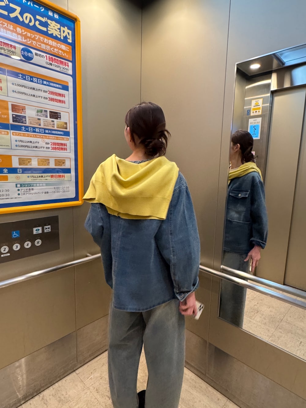 イエロー系のニット/セーター、ブルー系のデニムジャケット、ブルー系のデニムパンツを着用したレディースの春コーディネートの2枚目の写真