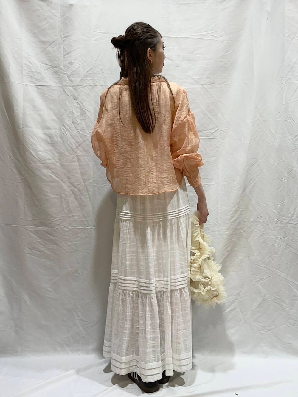 ホワイト系のハンドバッグ、ホワイト系のTシャツ/カットソー、ホワイト系のスカートを着用したレディースの夏コーディネートの2枚目の写真