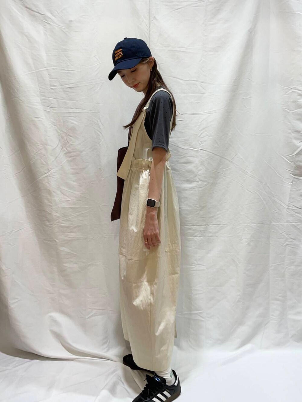 ブラウン系のトートバッグ、ホワイト系のワンピース、グレー系のTシャツ/カットソーを着用したレディースの夏コーディネートの2枚目の写真