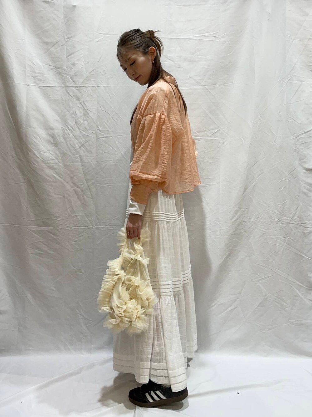 ホワイト系のハンドバッグ、ホワイト系のTシャツ/カットソー、ホワイト系のスカートを着用したレディースの夏コーディネートの3枚目の写真