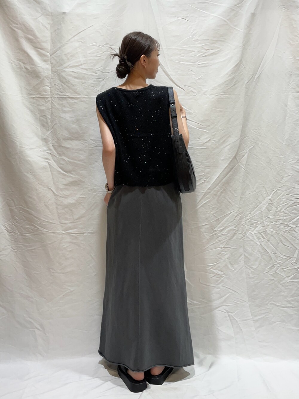 ブラック系のショルダーバッグ、ブラック系のスカート、ブラック系のニット/セーターを着用したレディースの秋コーディネートの3枚目の写真