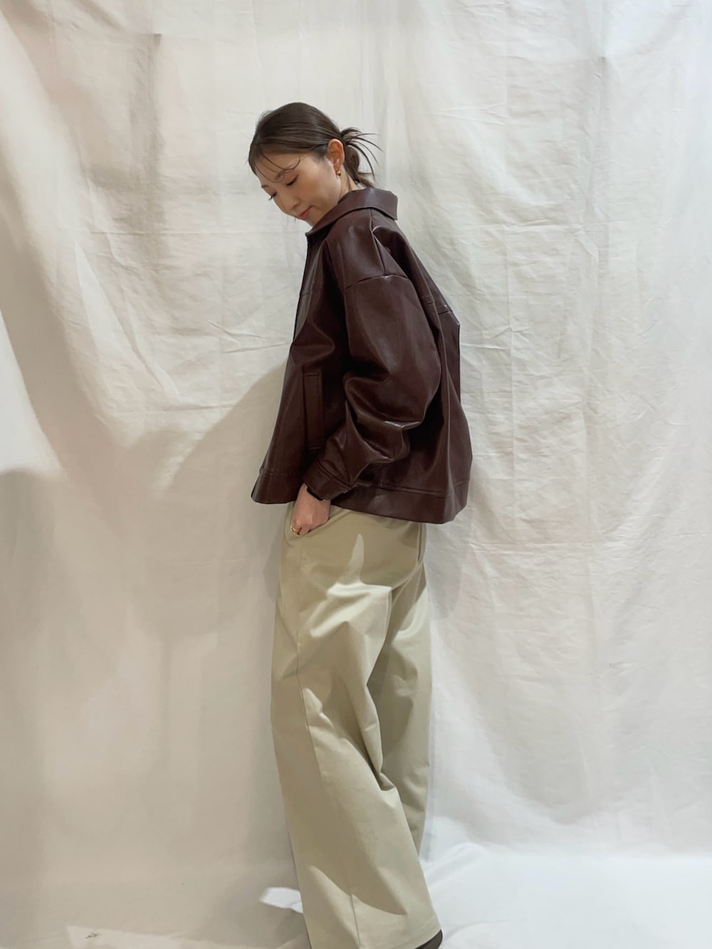 ホワイト系のニット/セーター、ベージュ系のその他パンツ、ブラウン系のブルゾンを着用したレディースの春コーディネートの2枚目の写真