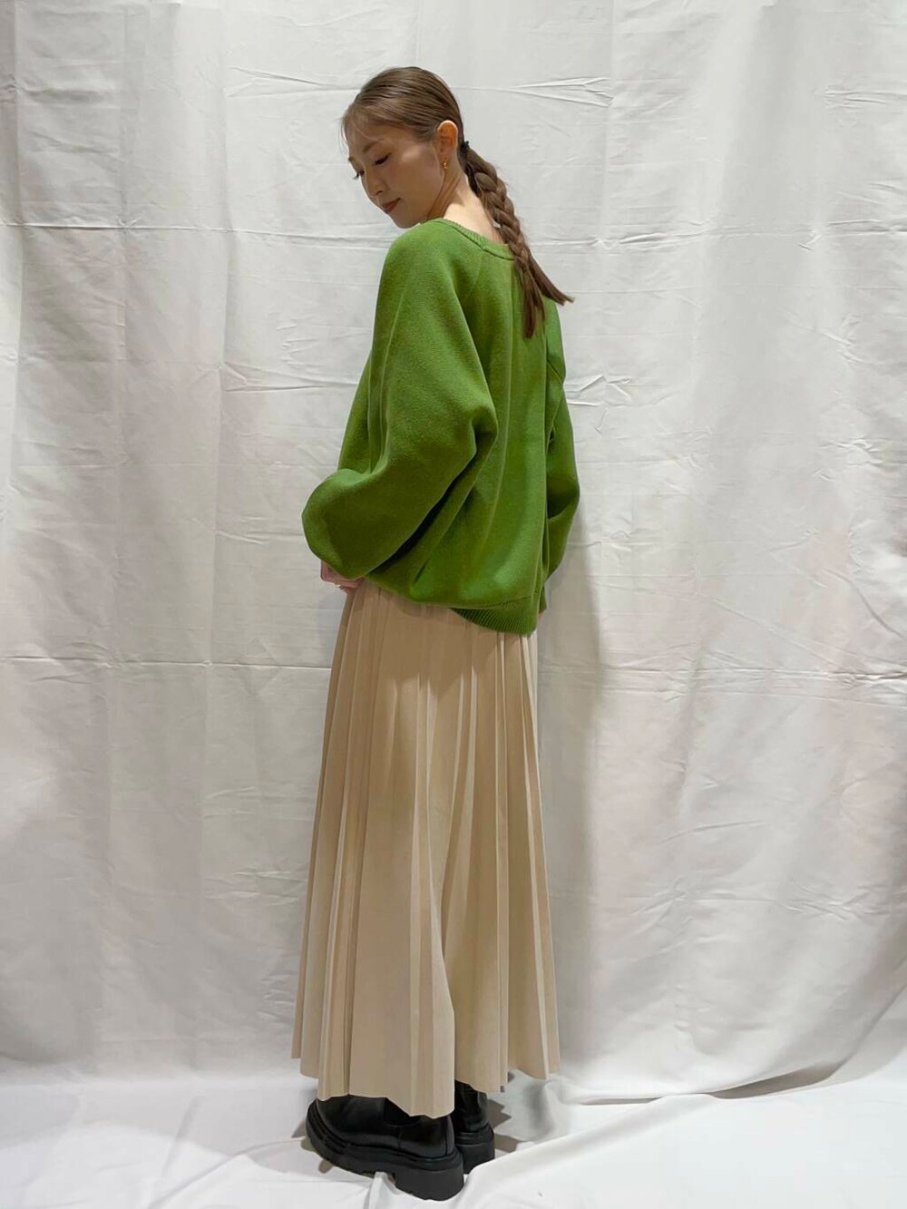 ベージュ系のスカート、グリーン系のニット/セーターを着用したレディースの冬コーディネートの2枚目の写真