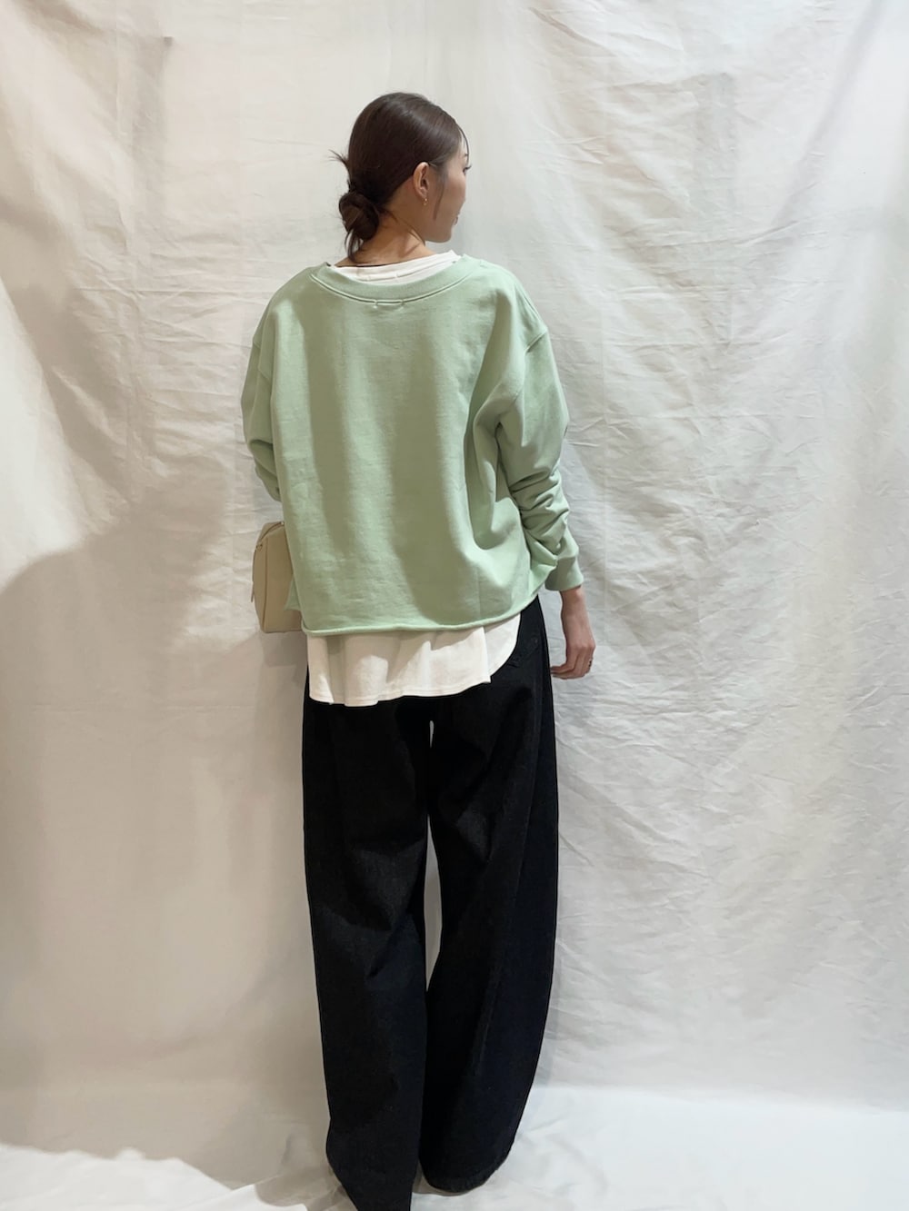 グリーン系のスウェット、ブラック系のその他パンツを着用したレディースの春コーディネートの3枚目の写真