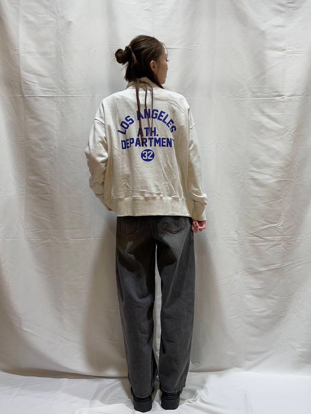 グレー系のデニムパンツ、ベージュ系のスウェットを着用したレディースの冬コーディネートの2枚目の写真