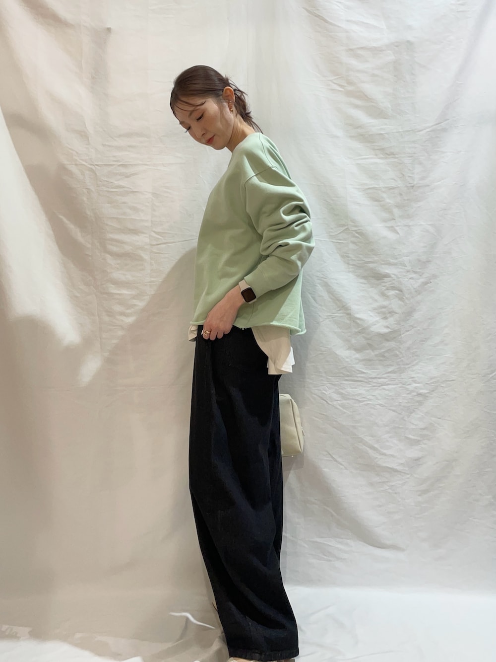 グリーン系のスウェット、ブラック系のその他パンツを着用したレディースの春コーディネートの2枚目の写真