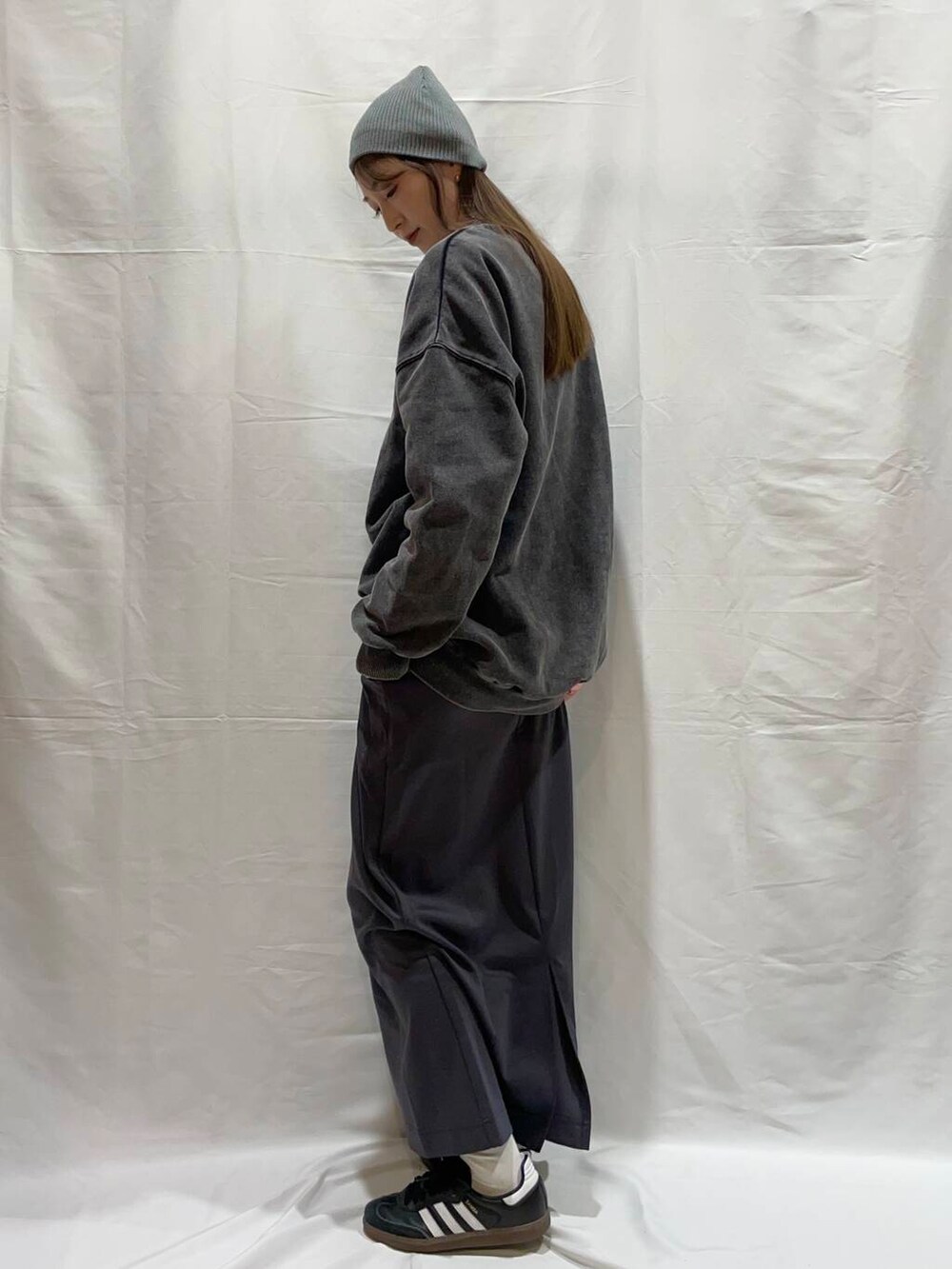 グレー系のスカート、ブラック系のTシャツ/カットソーを着用したレディースの冬コーディネートの2枚目の写真