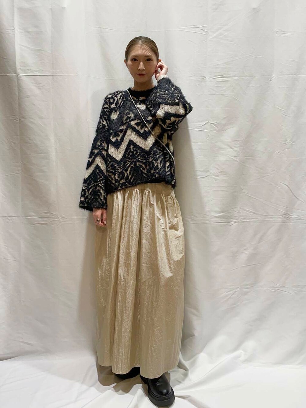 ベージュ系のスカート、ブラック系のニット/セーターを着用したレディースの冬コーディネートの3枚目の写真