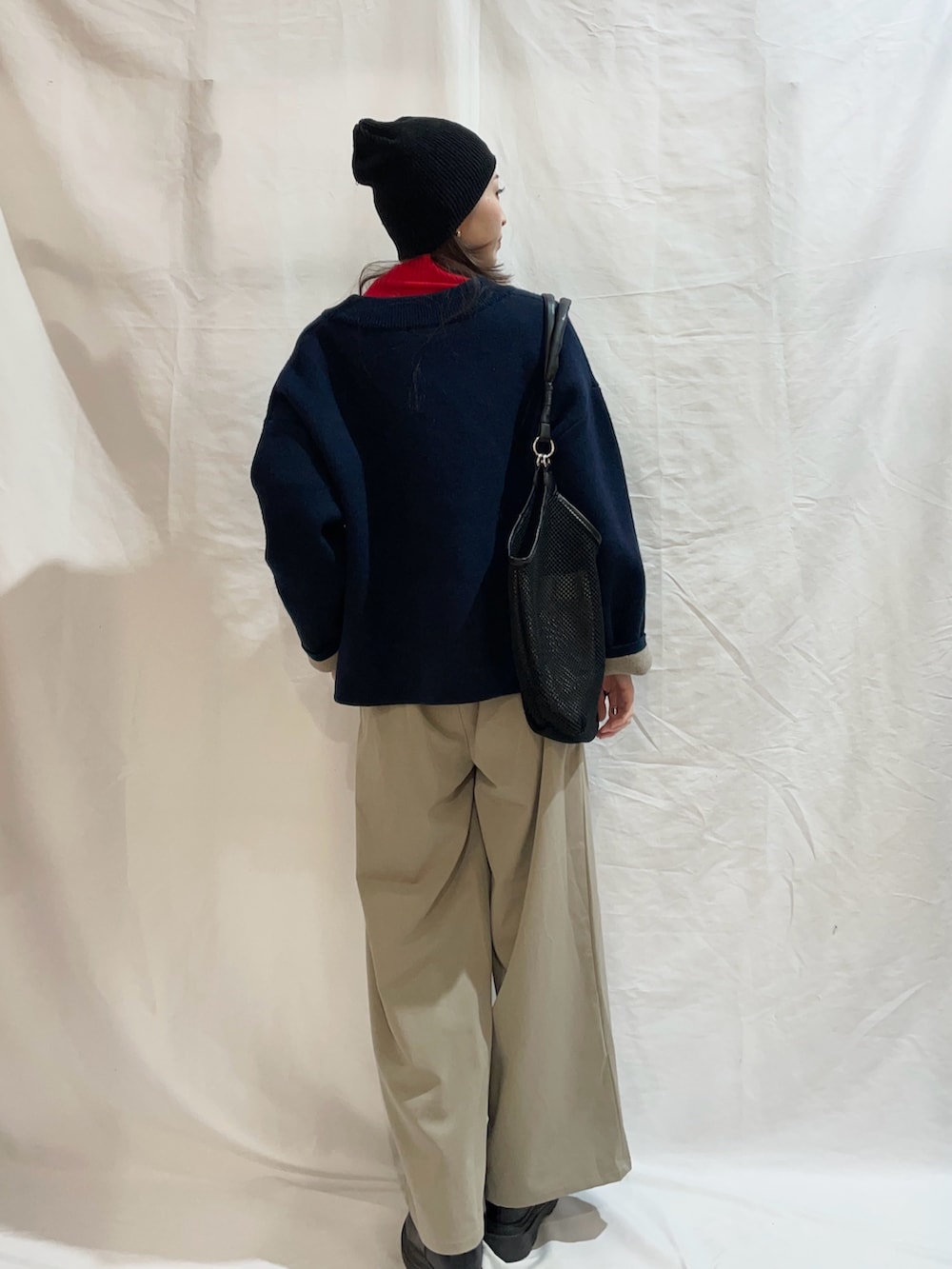 ベージュ系のその他パンツ、レッド系のニット/セーターを着用したレディースの冬コーディネートの2枚目の写真