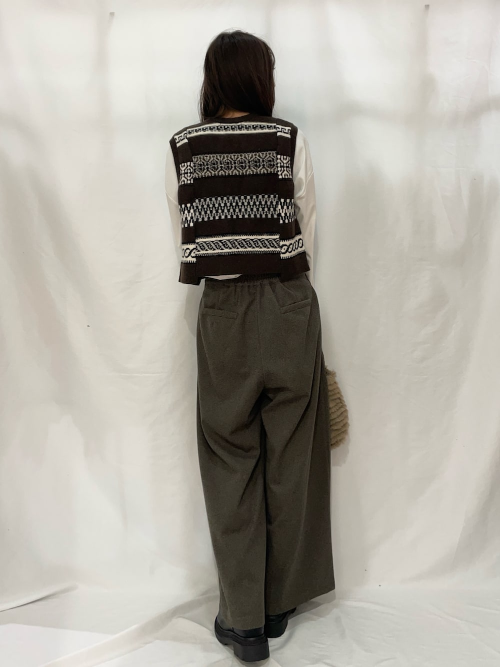 ブラウン系のその他パンツ、ブラウン系のベストを着用したレディースの冬コーディネートの3枚目の写真