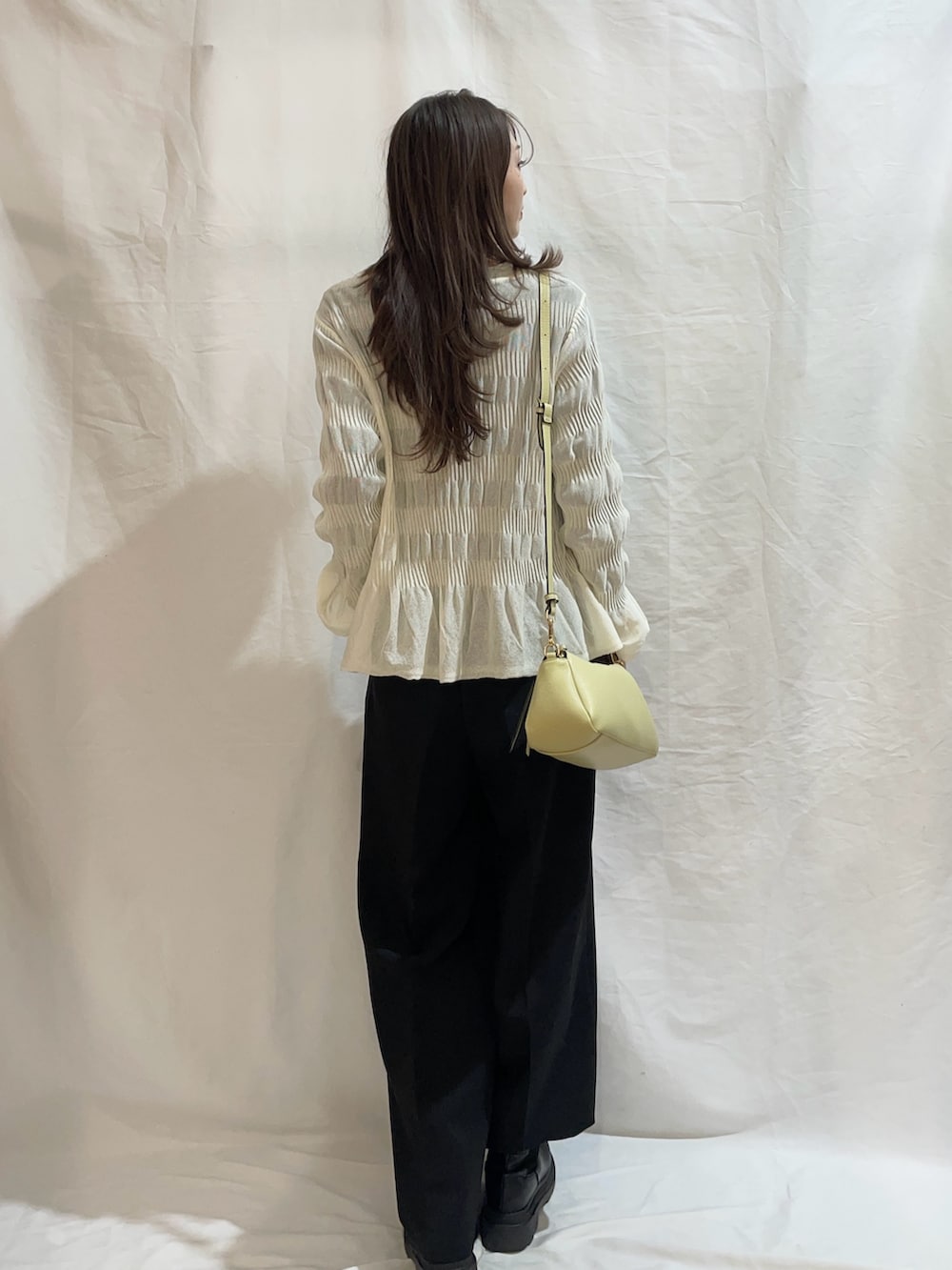 ブラック系のその他パンツ、ホワイト系のニット/セーターを着用したレディースの冬コーディネートの2枚目の写真