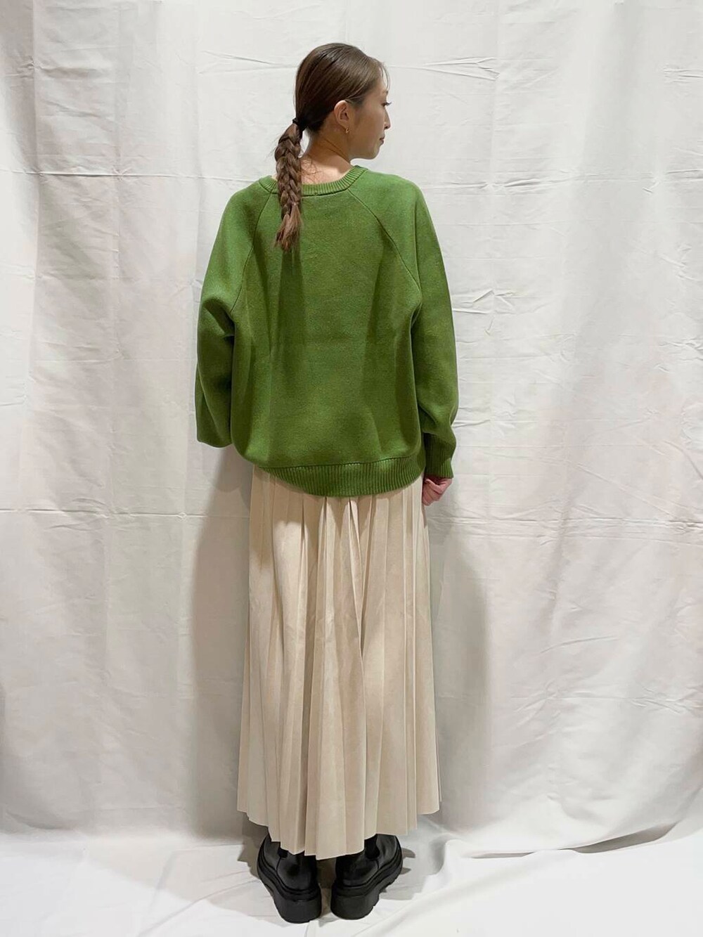 ベージュ系のスカート、グリーン系のニット/セーターを着用したレディースの冬コーディネートの3枚目の写真