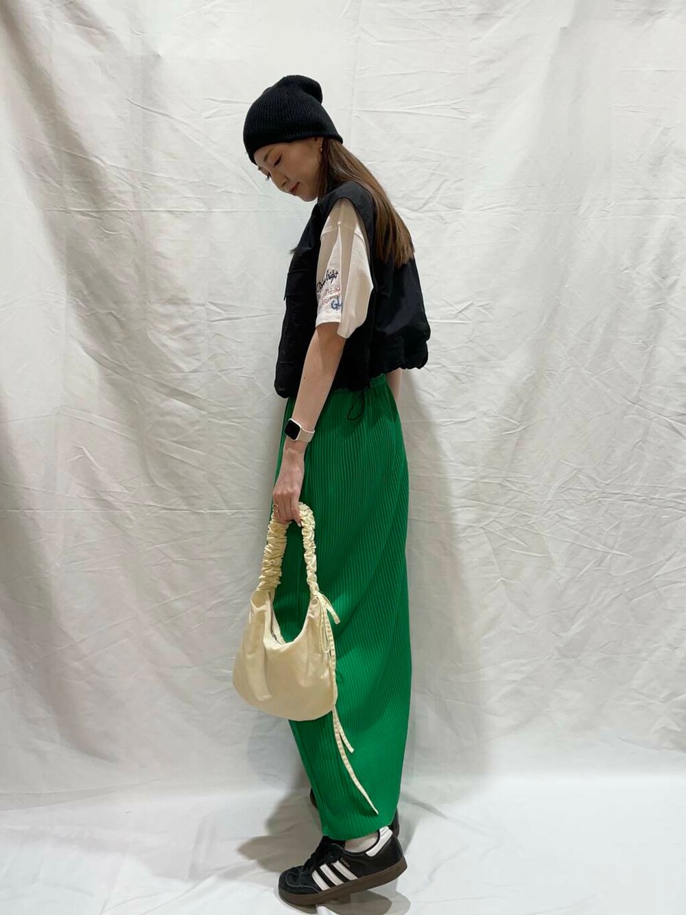 ホワイト系のハンドバッグ、ブラック系のその他アウター、ホワイト系のTシャツ/カットソーを着用したレディースの夏コーディネートの3枚目の写真