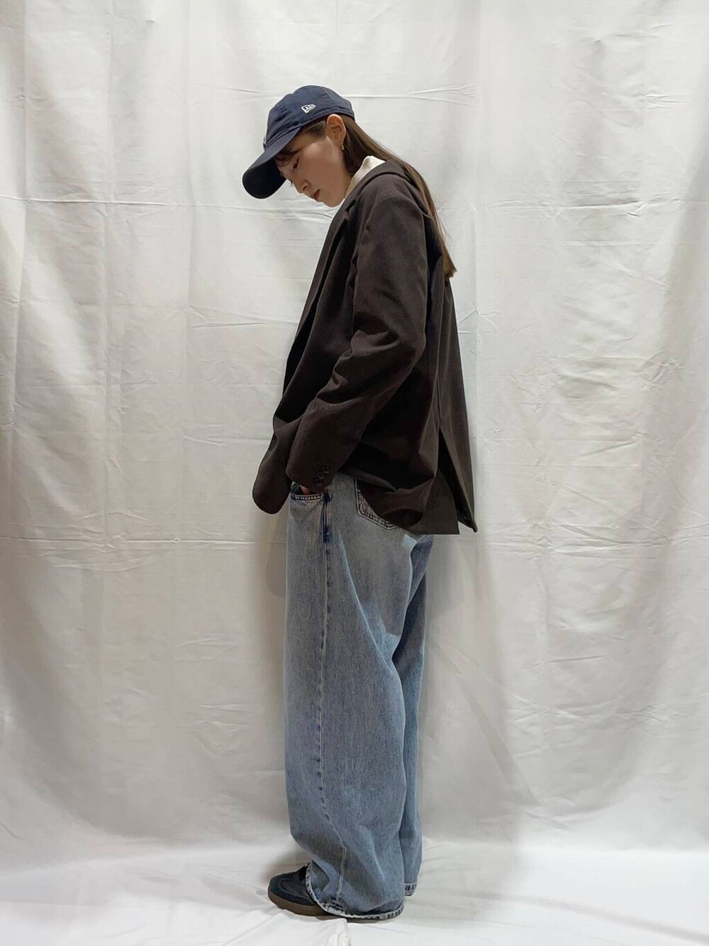 ブルー系のデニムパンツ、ブラウン系のその他アウター、ホワイト系のニット/セーターを着用したレディースの冬コーディネートの3枚目の写真