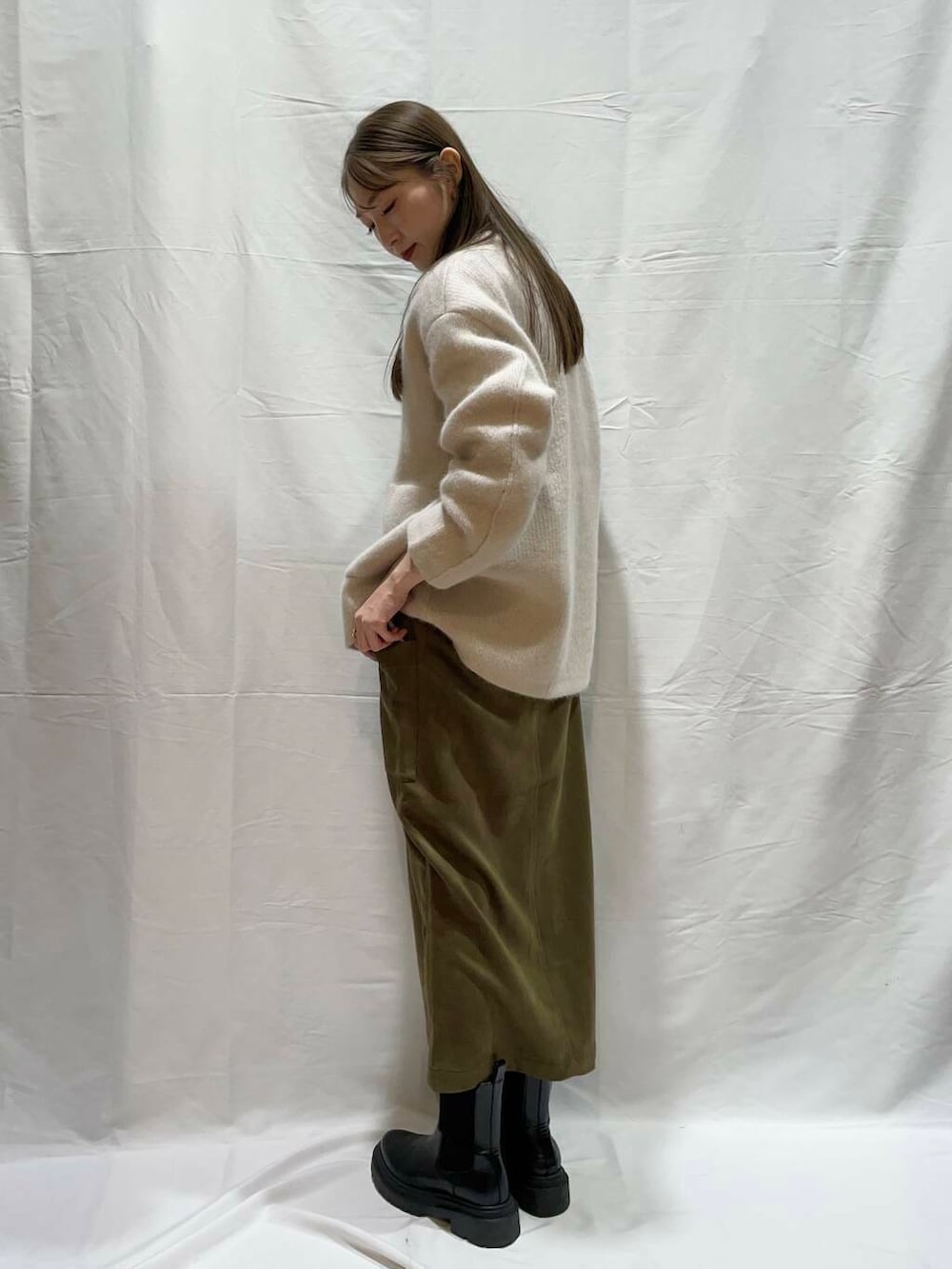 グリーン系のスカート、グレー系のカーディガン/ボレロを着用したレディースの冬コーディネートの2枚目の写真