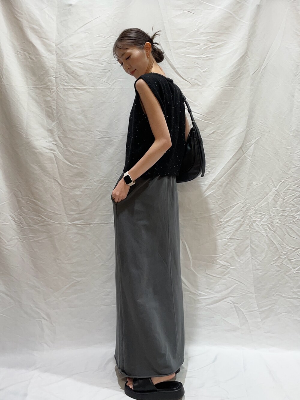 ブラック系のショルダーバッグ、ブラック系のスカート、ブラック系のニット/セーターを着用したレディースの秋コーディネートの2枚目の写真