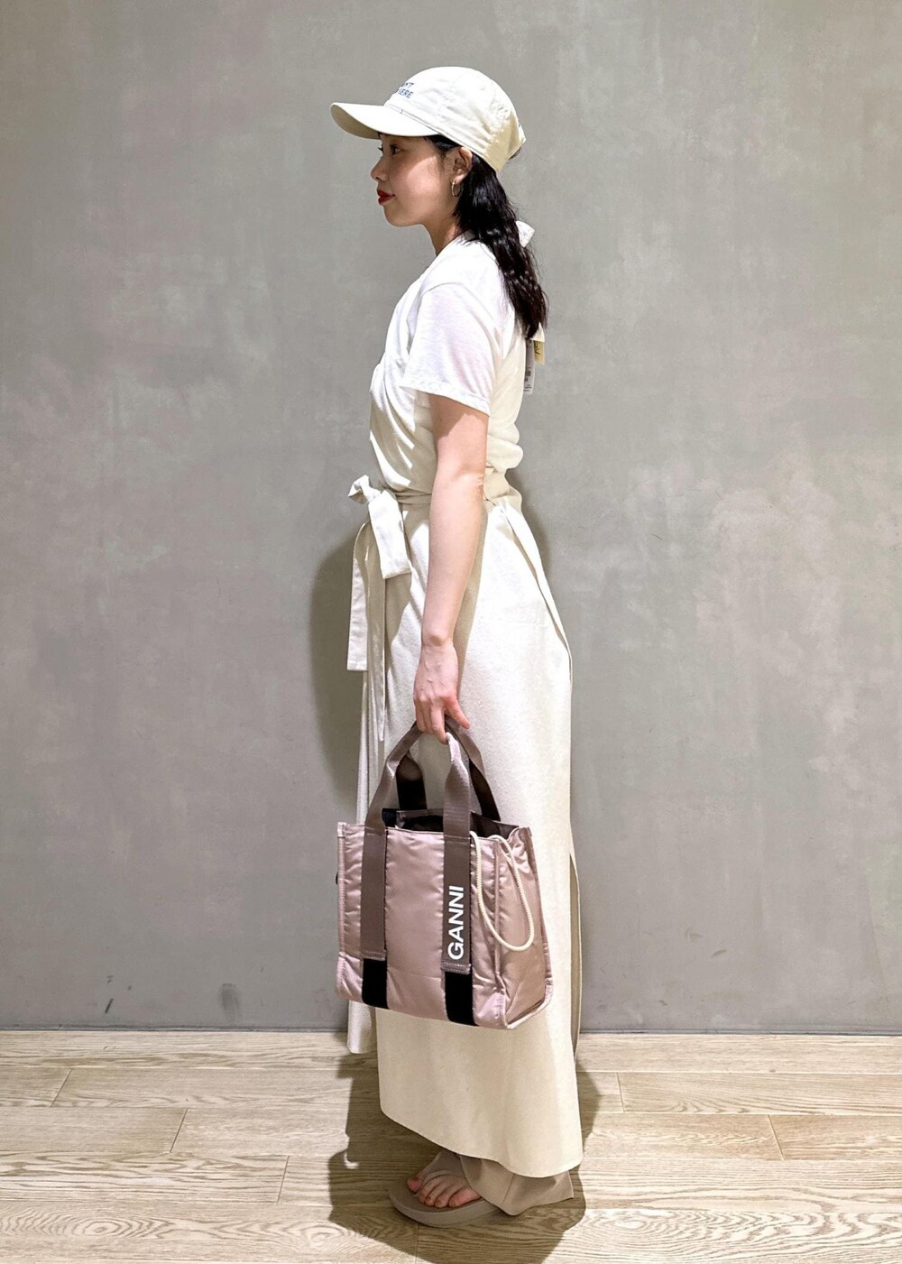 グレー系のショルダーバッグ、ベージュ系のスラックスを着用したレディースの夏コーディネートの2枚目の写真