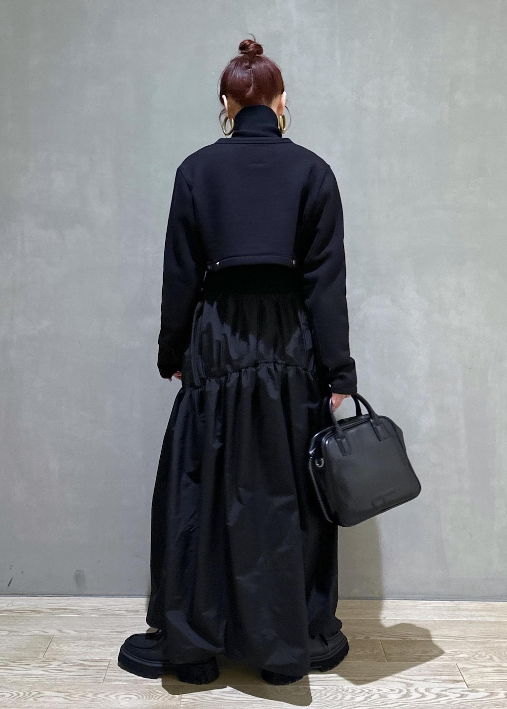 ブラック系のボストンバッグ、ブラック系のブーツ、ブラック系のカーディガン/ボレロを着用したレディースの秋コーディネートの3枚目の写真