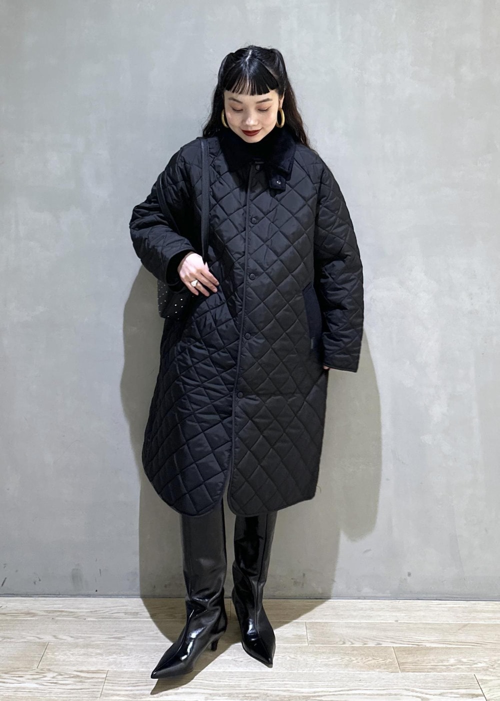 ブラック系のニット/セーター、ブラック系のナイロンジャケット、ブラック系のブーツを着用したレディースの秋コーディネートの4枚目の写真