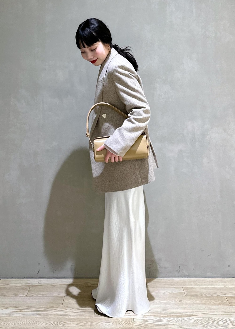 ホワイト系のTシャツ/カットソー、ベージュ系のその他アウター、ベージュ系のハンドバッグを着用したレディースの冬コーディネートの4枚目の写真