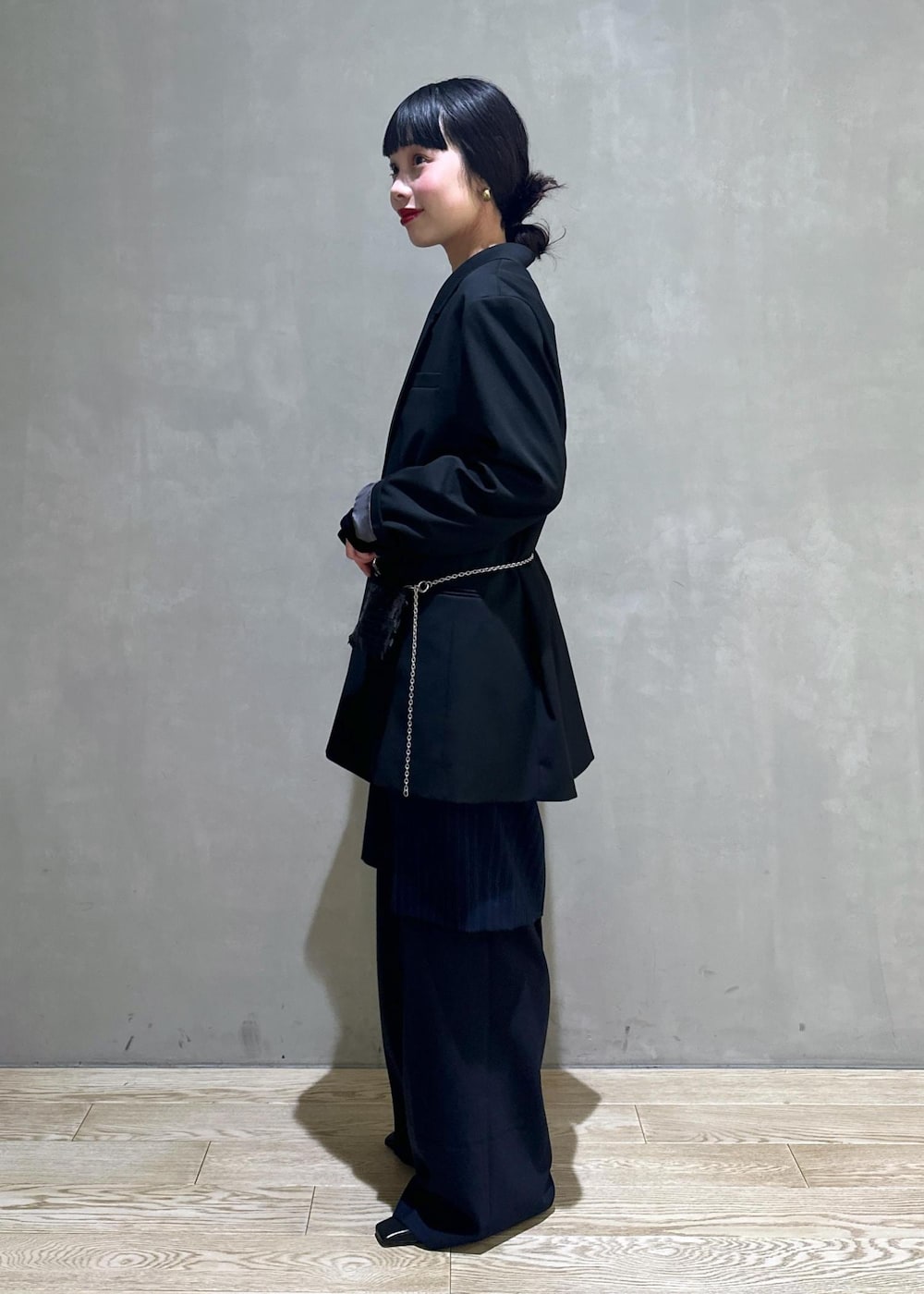 ブラック系のショルダーバッグ、ブラック系のテーラードジャケット、ブラック系のTシャツ/カットソーを着用したレディースの冬コーディネートの3枚目の写真