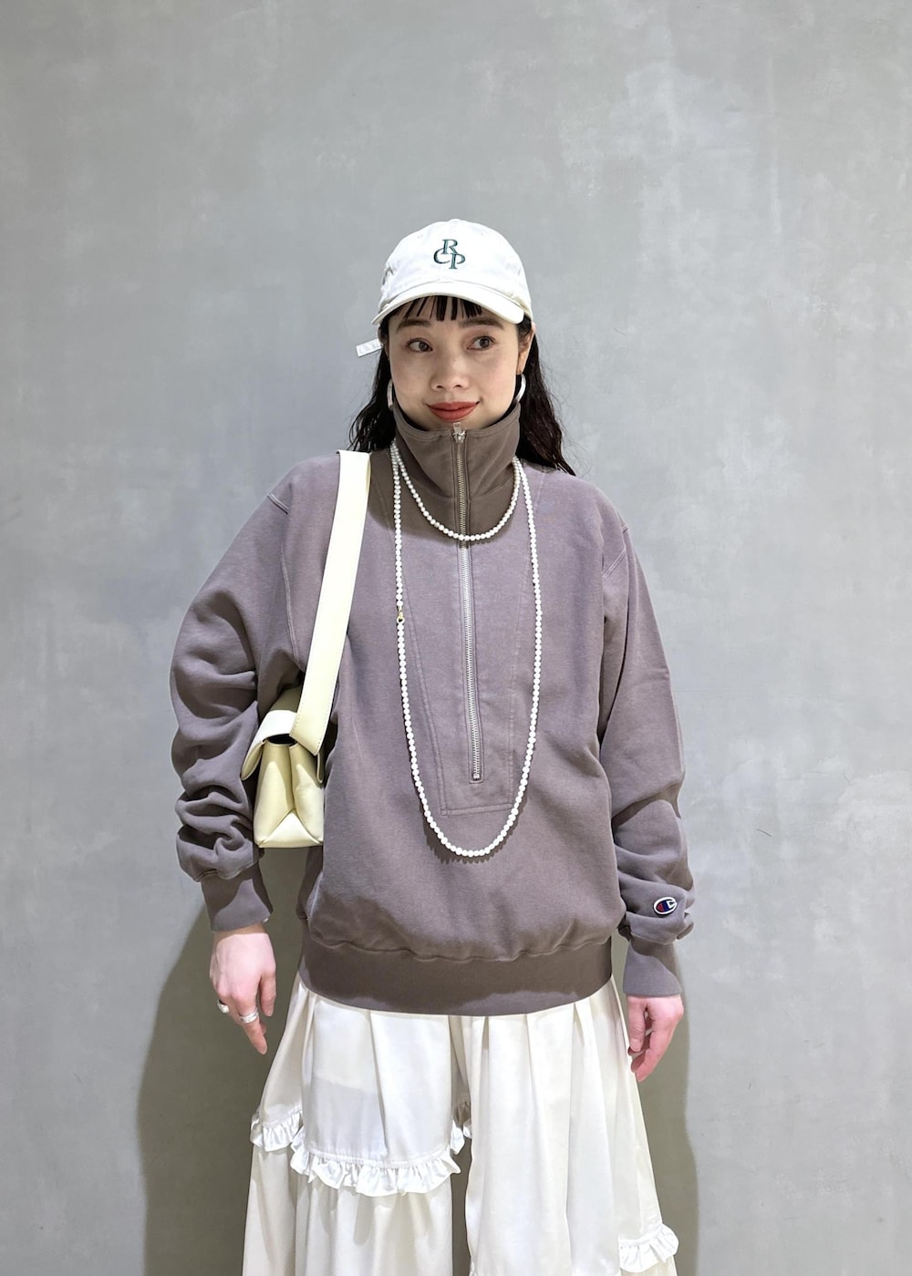 ホワイト系のスカート、ブラウン系のスウェット、ベージュ系のサンダルを着用したレディースの冬コーディネートの9枚目の写真