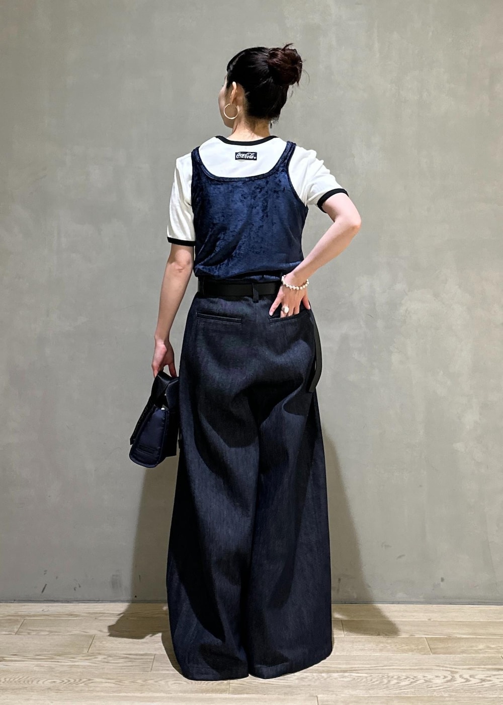 ブルー系のデニムパンツ、ブルー系のショルダーバッグ、ブルー系のタンクトップを着用したレディースの夏コーディネートの4枚目の写真