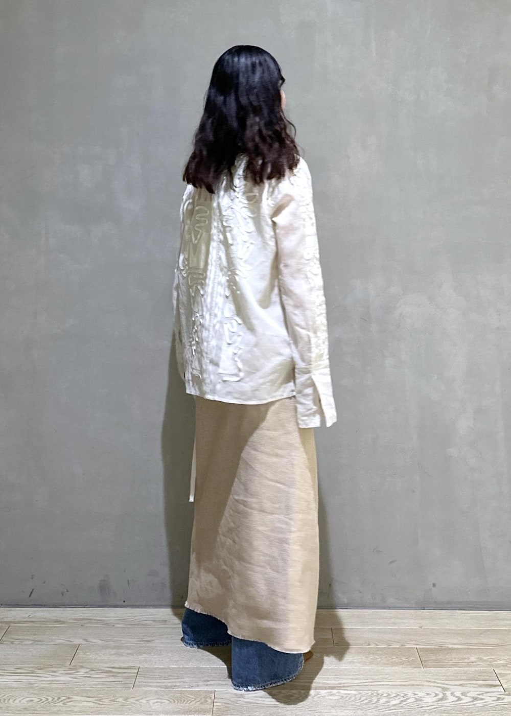 ベージュ系のスカート、ホワイト系のシャツ/ブラウス、ブルー系のデニムパンツを着用したレディースの冬コーディネートの4枚目の写真