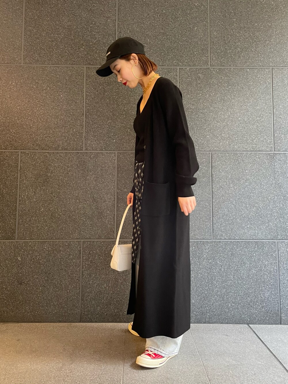 ブラック系のカーディガン/ボレロ、ブルー系のデニムパンツ、レッド系のスニーカーを着用したレディースの冬コーディネートの2枚目の写真