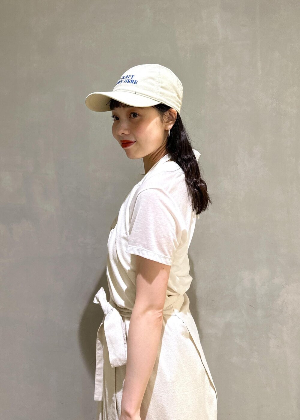 グレー系のショルダーバッグ、ベージュ系のスラックスを着用したレディースの夏コーディネートの5枚目の写真