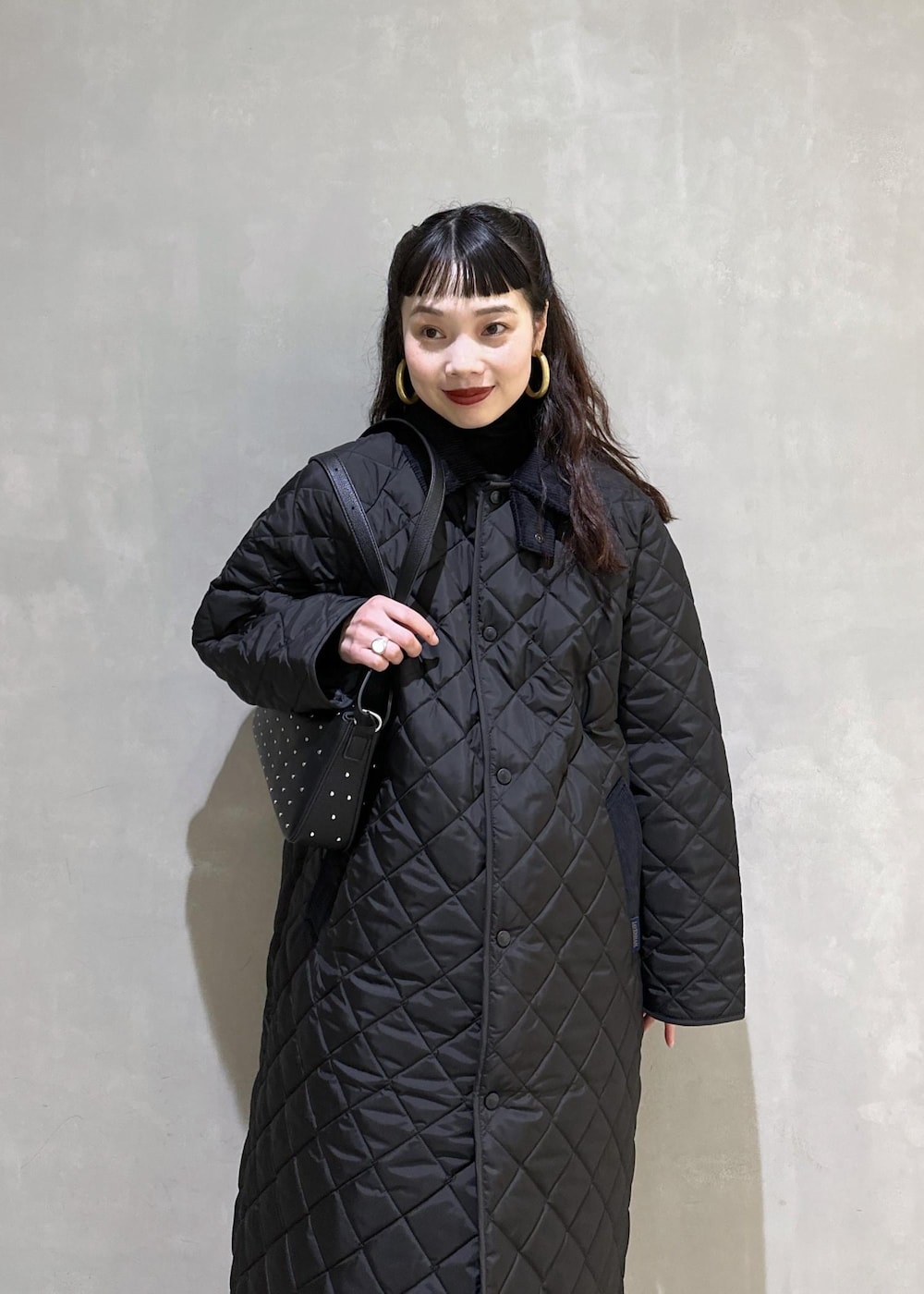 ブラック系のニット/セーター、ブラック系のナイロンジャケット、ブラック系のブーツを着用したレディースの秋コーディネートの6枚目の写真