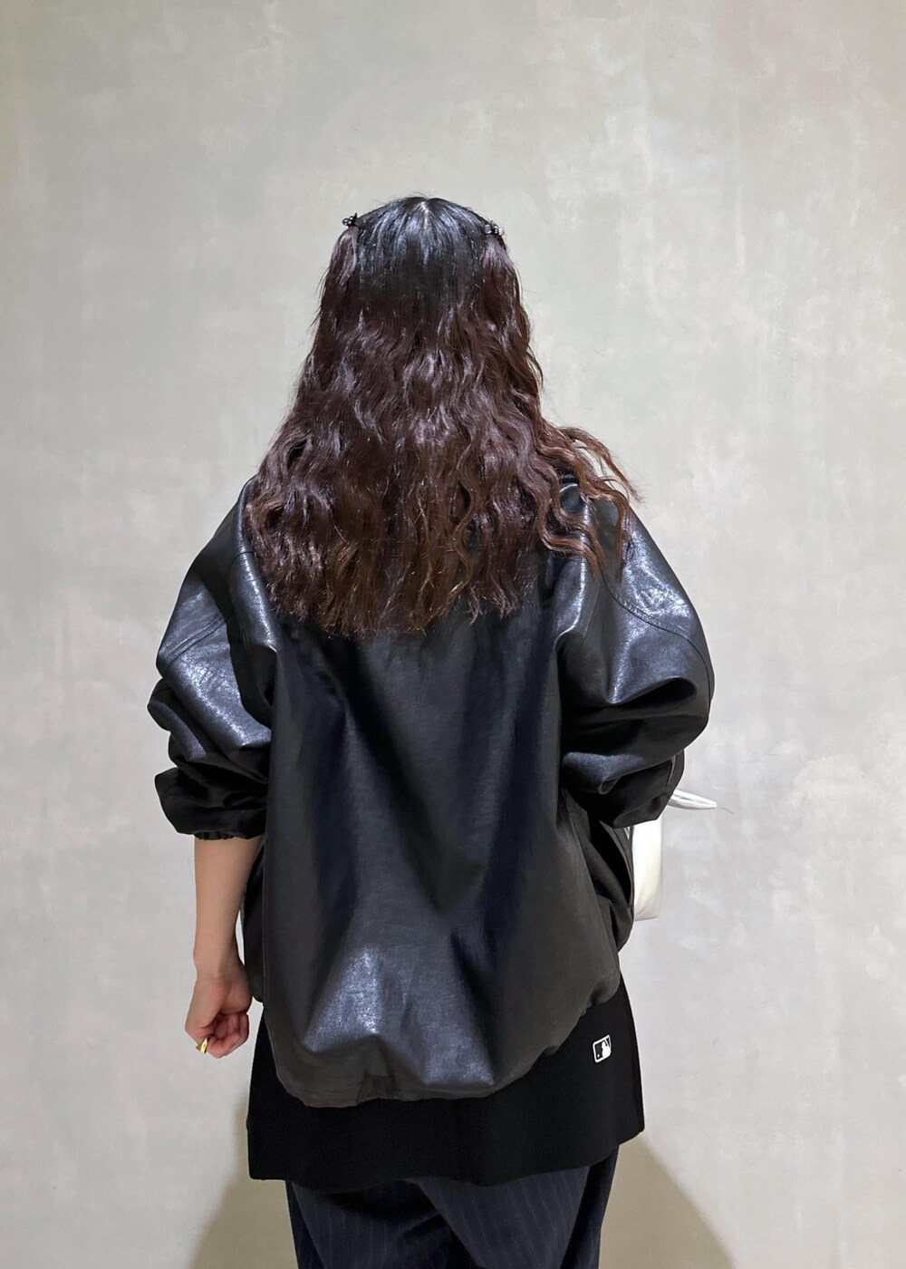 シルバー系のショルダーバッグ、シルバー系のブーツ、ブラック系のスラックスを着用したレディースの秋コーディネートの8枚目の写真