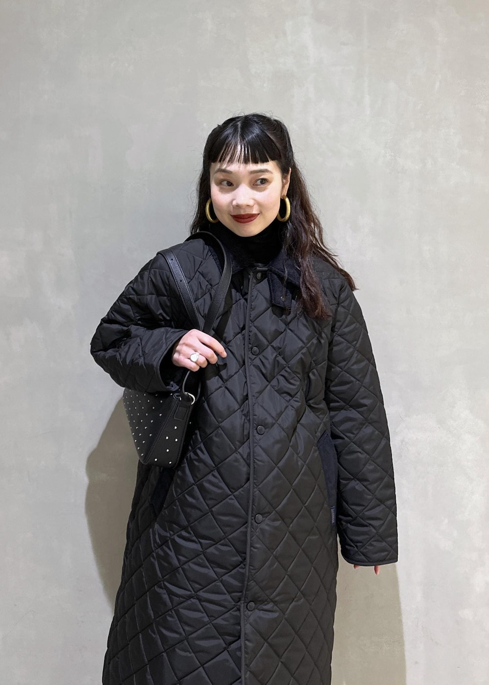 ブラック系のニット/セーター、ブラック系のナイロンジャケット、ブラック系のブーツを着用したレディースの秋コーディネートの5枚目の写真