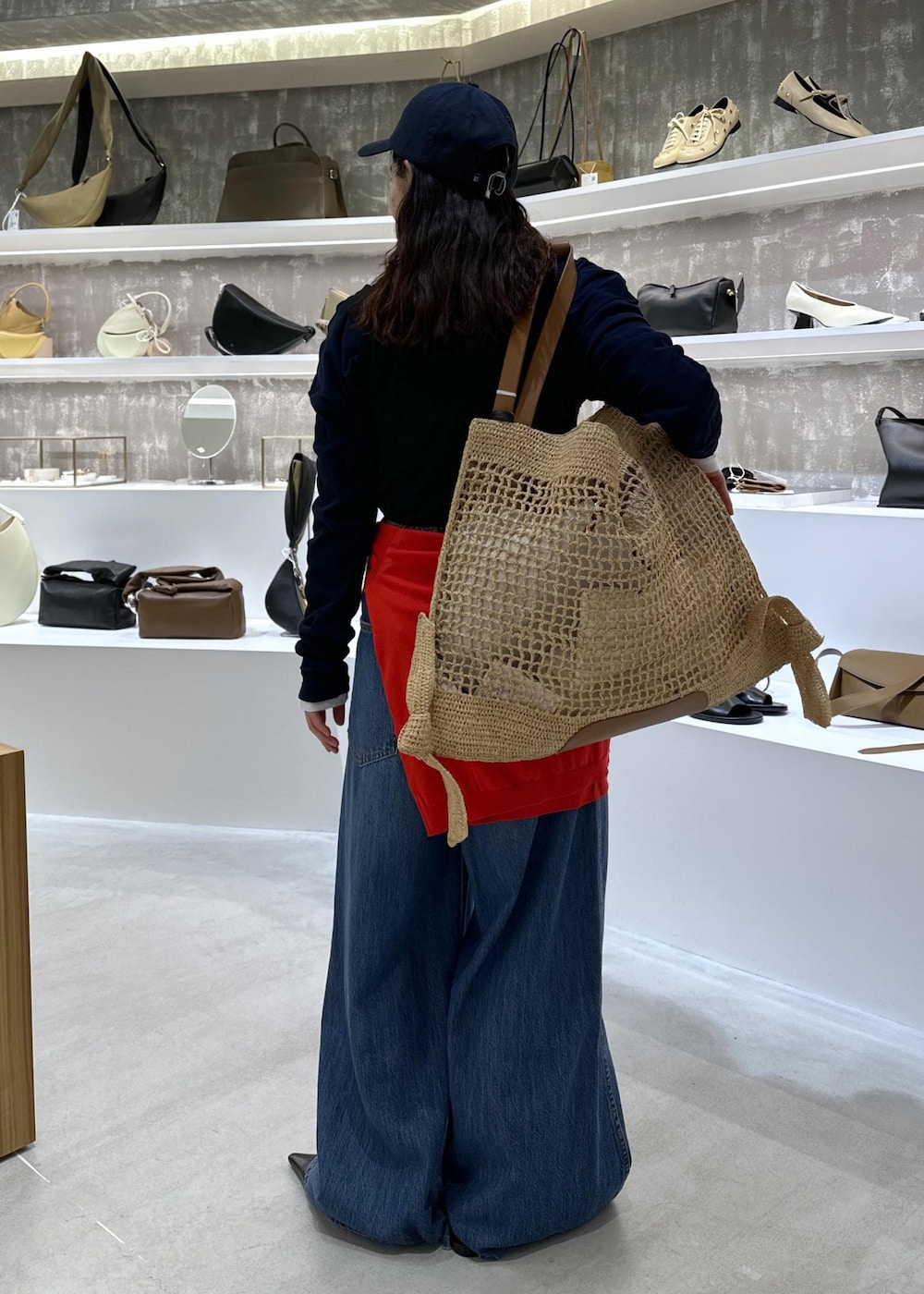 ブラック系のパンプス、ブルー系のデニムパンツ、ホワイト系のTシャツ/カットソーを着用したレディースの春コーディネートの4枚目の写真