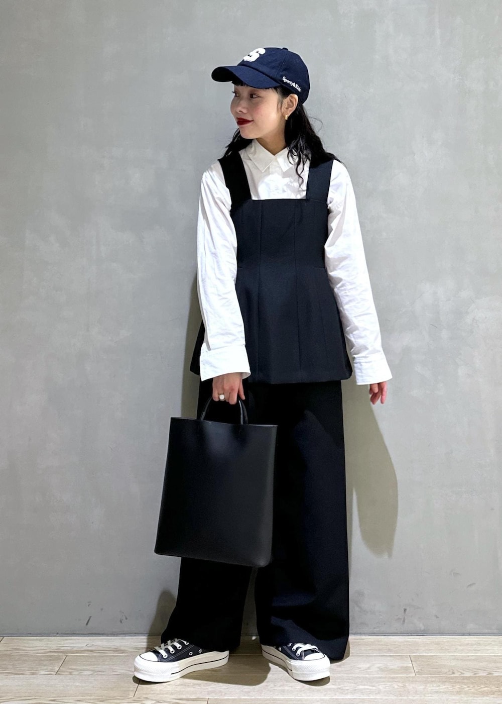 ブラック系のトートバッグ、ブラック系のつなぎ/オールインワンを着用したレディースの冬コーディネートの2枚目の写真