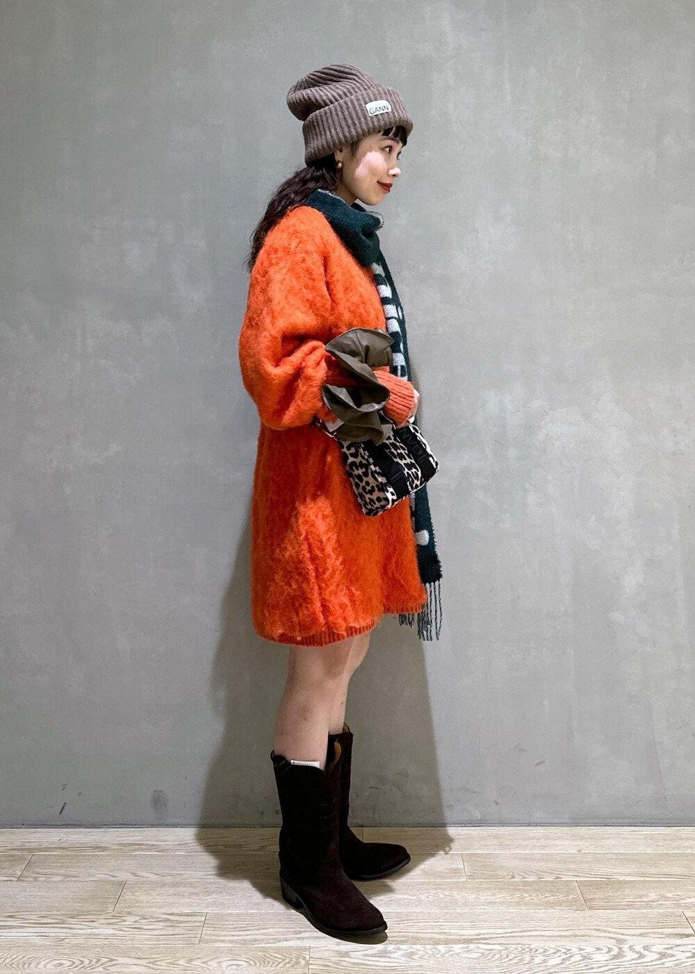 ベージュ系のトートバッグ、オレンジ系のワンピース、ブラウン系のシュシュを着用したレディースの秋コーディネートの5枚目の写真