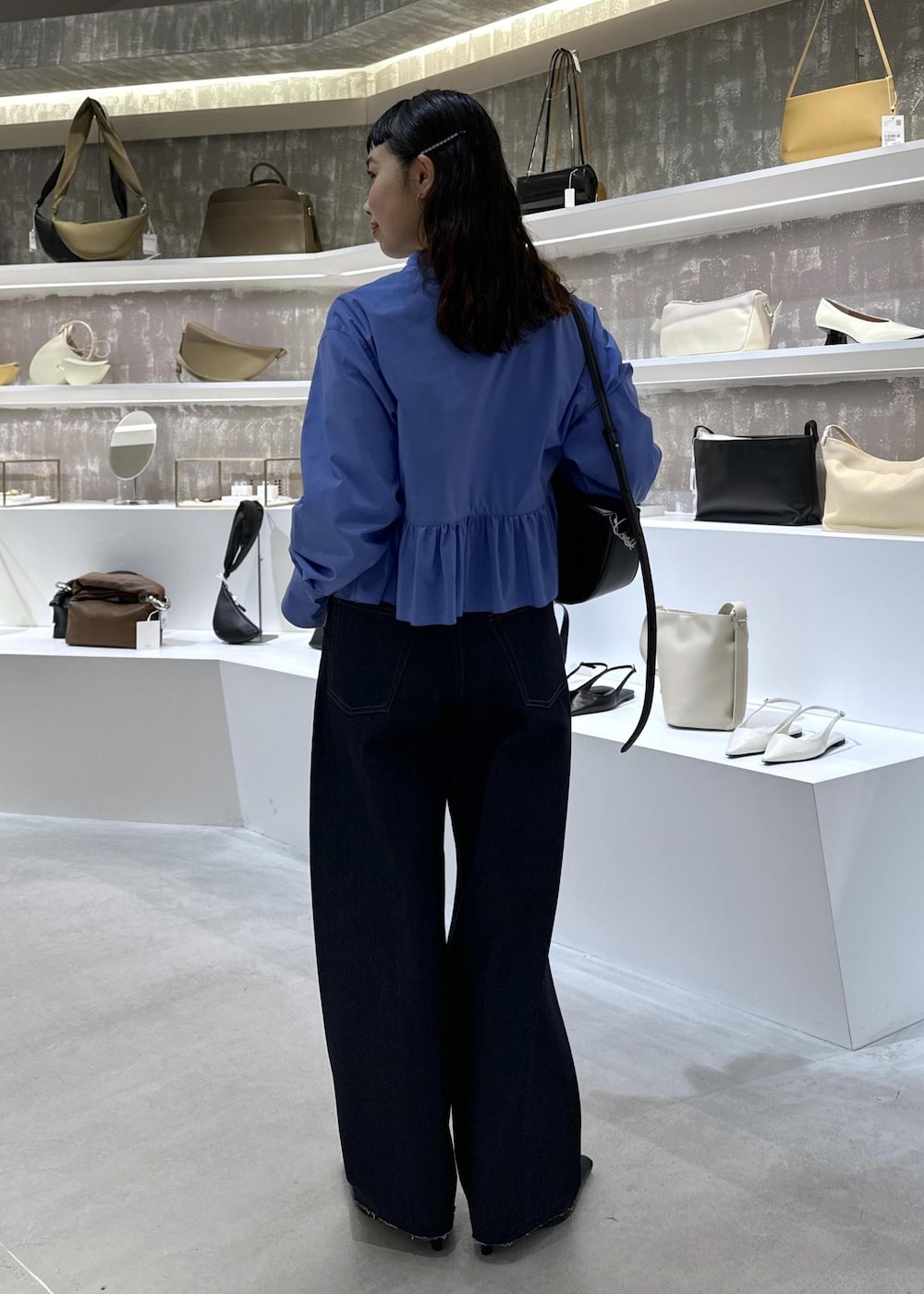 ブラック系のショルダーバッグ、ブルー系のデニムパンツ、ブルー系のシャツ/ブラウスを着用したレディースの春コーディネートの3枚目の写真