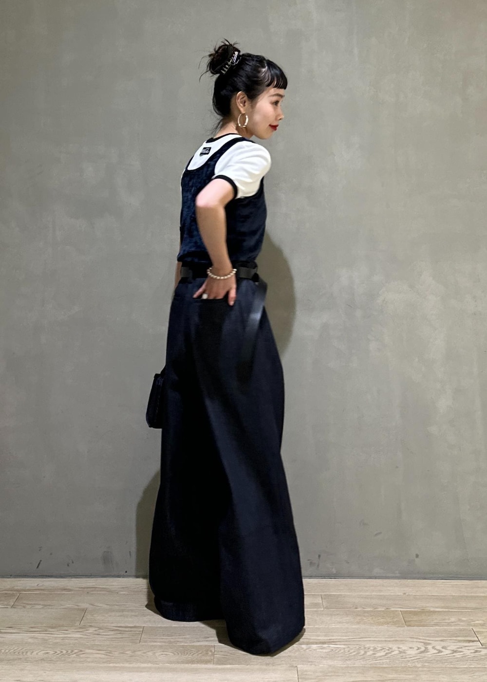 ブルー系のデニムパンツ、ブルー系のショルダーバッグ、ブルー系のタンクトップを着用したレディースの夏コーディネートの5枚目の写真